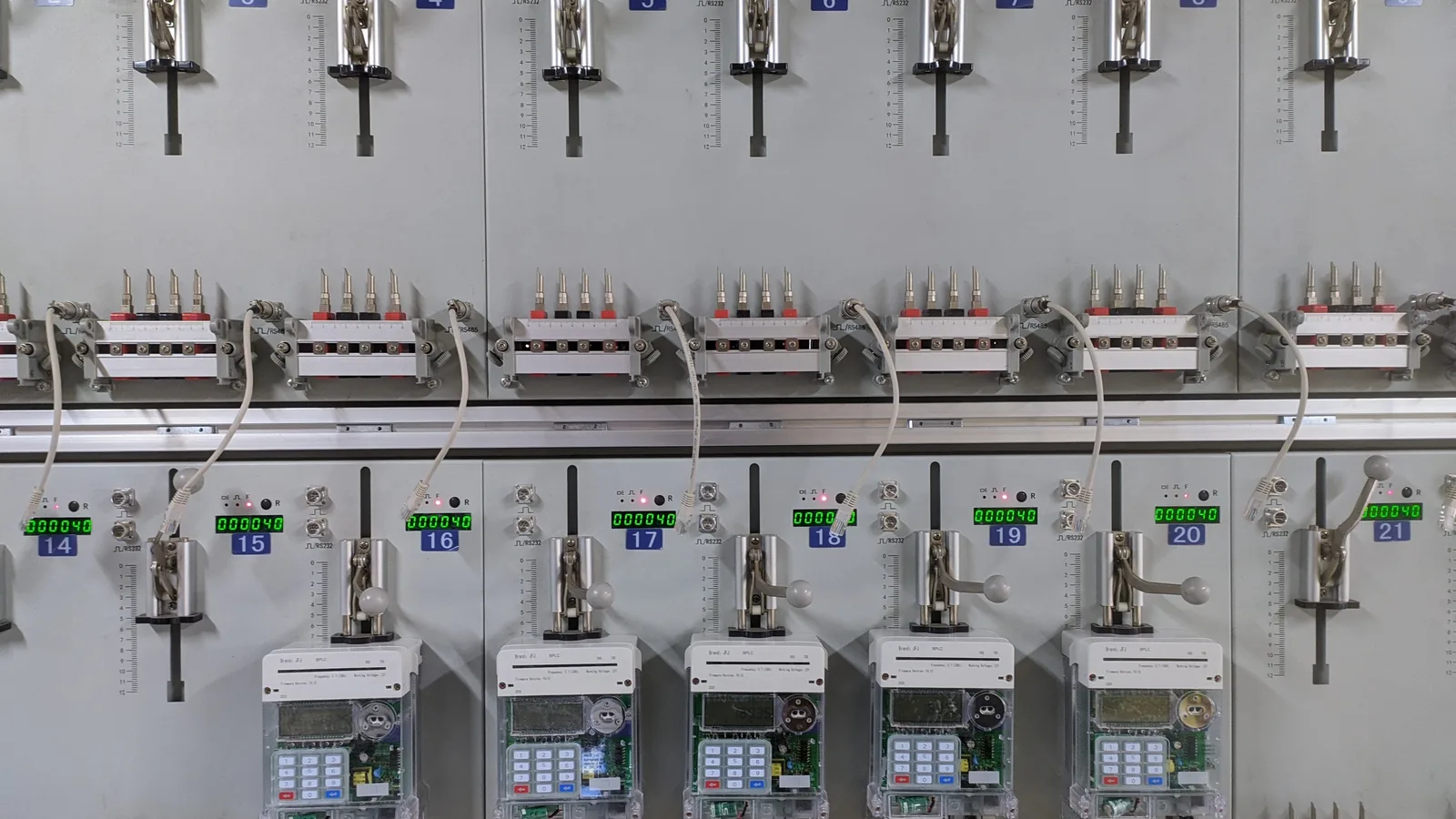 An automatic test bench checking a row of electricity meters, the kind of inspection step a quality management system records